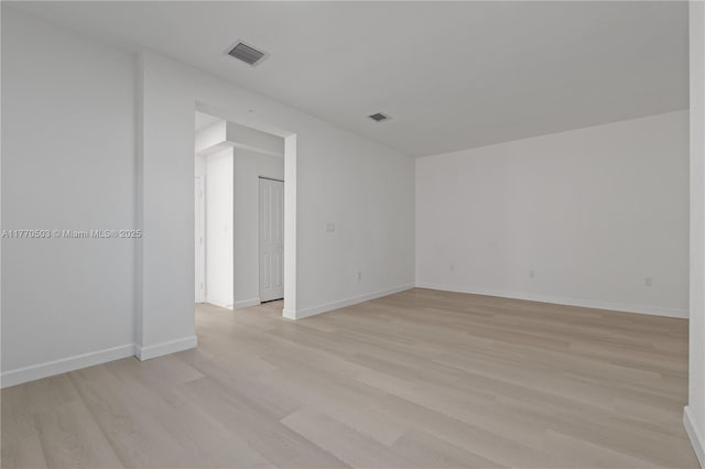 unfurnished room with light wood-style flooring, baseboards, and visible vents