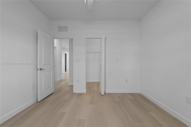 unfurnished bedroom with visible vents, baseboards, light wood-type flooring, and a closet