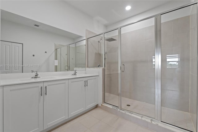 full bathroom featuring a sink, tile patterned flooring, double vanity, and a stall shower