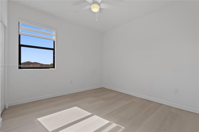 unfurnished room featuring baseboards, light wood finished floors, and a ceiling fan