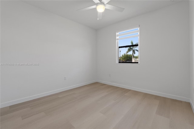spare room featuring light wood-type flooring, baseboards, and a ceiling fan