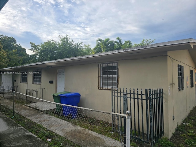 view of property exterior featuring fence and stucco siding
