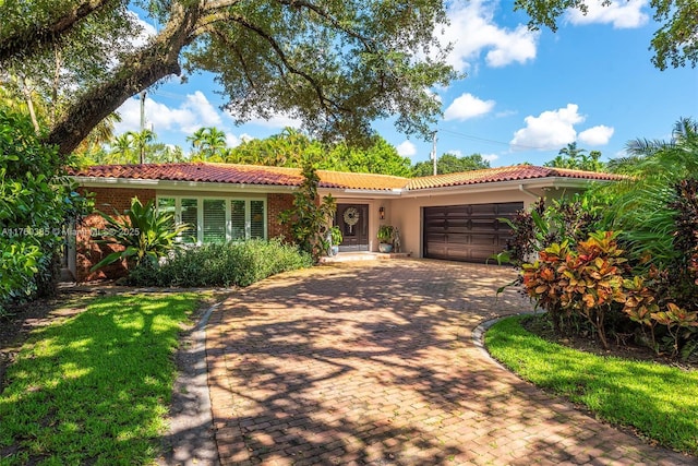 1414 Ferdinand St, Coral Gables, FL 33134 - ranch-style home with a tile roof, an attached garage, decorative driveway, and stucco siding