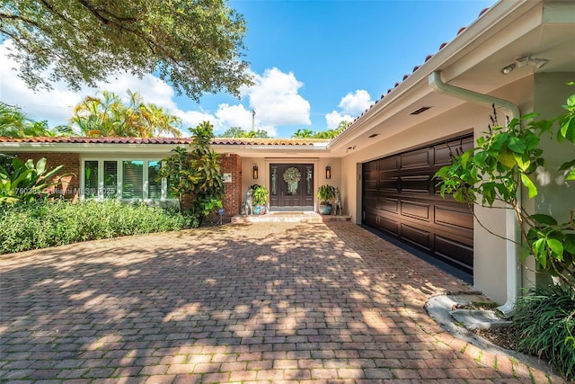 1414 Ferdinand St, Coral Gables, FL 33134 - view of front of home with a garage, stucco siding, and decorative driveway
