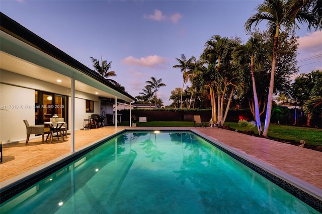 8360 SW 148th Dr, Palmetto Bay, FL 33158 - pool at dusk with a fenced in pool, a patio area, and fence