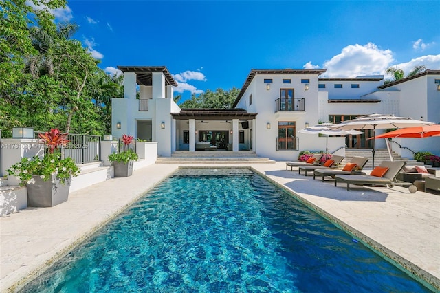 555 Arvida Pkwy, Coral Gables, FL 33156 - rear view of property featuring a fenced in pool, a patio, and stucco siding