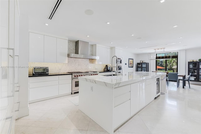 555 Arvida Pkwy, Coral Gables, FL 33156 - kitchen with tasteful backsplash, wall chimney exhaust hood, modern cabinets, a sink, and stainless steel stove