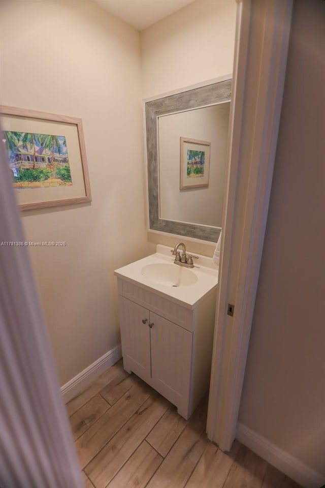 266 Iris Dr, Jupiter, FL 33458 - bathroom featuring wood finished floors, vanity, and baseboards
