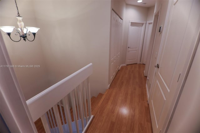 266 Iris Dr, Jupiter, FL 33458 - corridor featuring light wood-style floors, a notable chandelier, and an upstairs landing