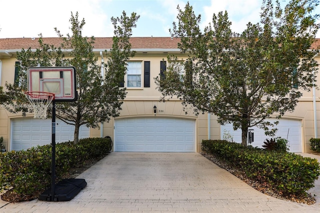 266 Iris Dr, Jupiter, FL 33458 - view of front of property featuring an attached garage, decorative driveway, and stucco siding