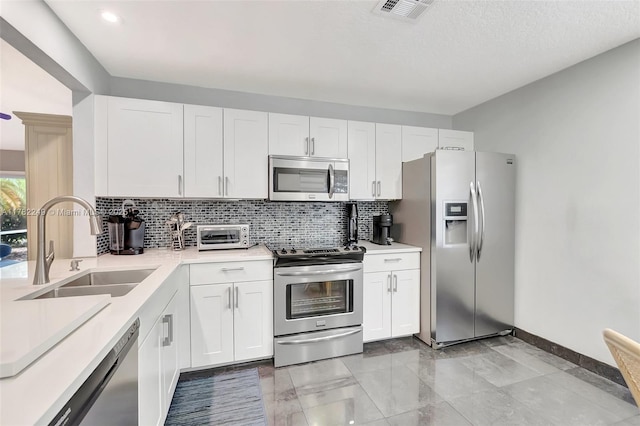 1237 NW 52nd Way, Deerfield Beach, FL 33442 - kitchen featuring visible vents, a sink, light countertops, stainless steel appliances, and backsplash