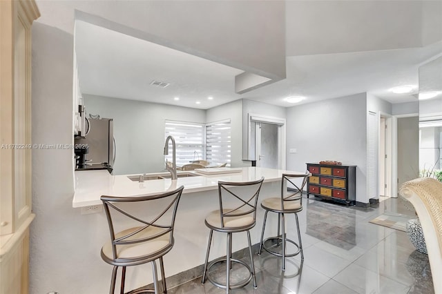 1237 NW 52nd Way, Deerfield Beach, FL 33442 - kitchen with a kitchen breakfast bar, tile patterned flooring, a peninsula, visible vents, and stainless steel appliances