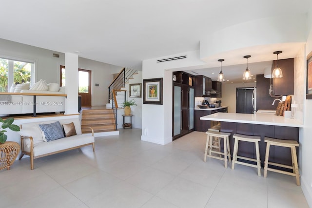 living room with light tile patterned flooring, baseboards, and stairs