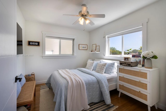 bedroom with baseboards, multiple windows, wood finished floors, and a ceiling fan