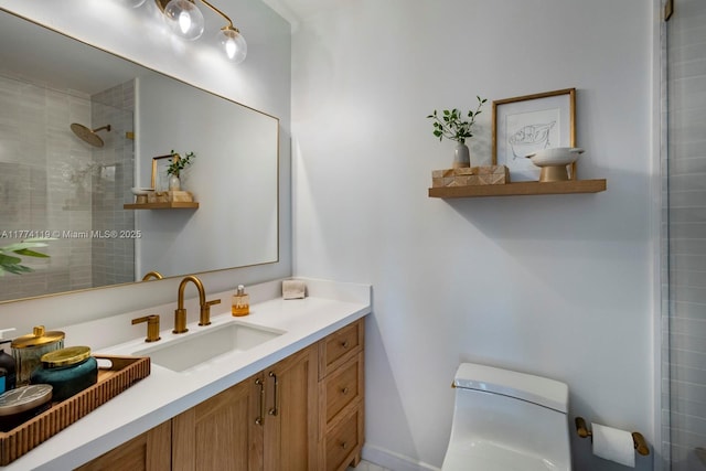 full bathroom featuring tiled shower, vanity, and toilet