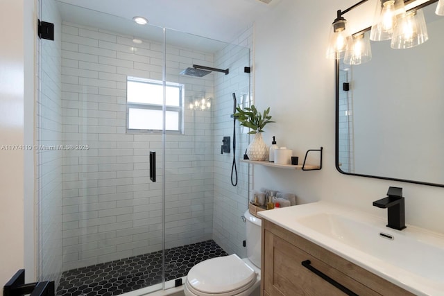 bathroom featuring toilet, a stall shower, and vanity