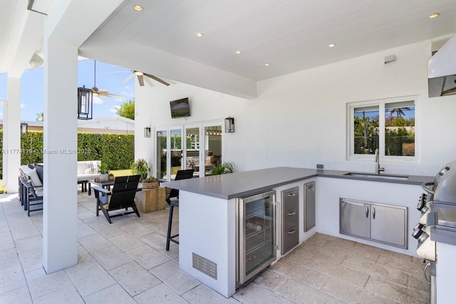 view of patio featuring a sink, a ceiling fan, area for grilling, wine cooler, and an outdoor hangout area