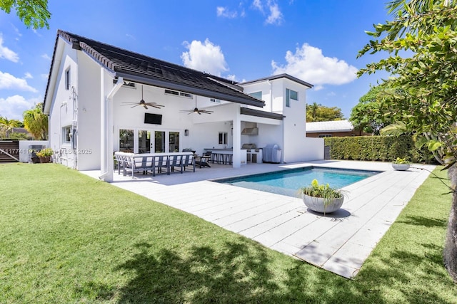 rear view of property featuring a yard, a patio area, ceiling fan, stucco siding, and a fenced in pool