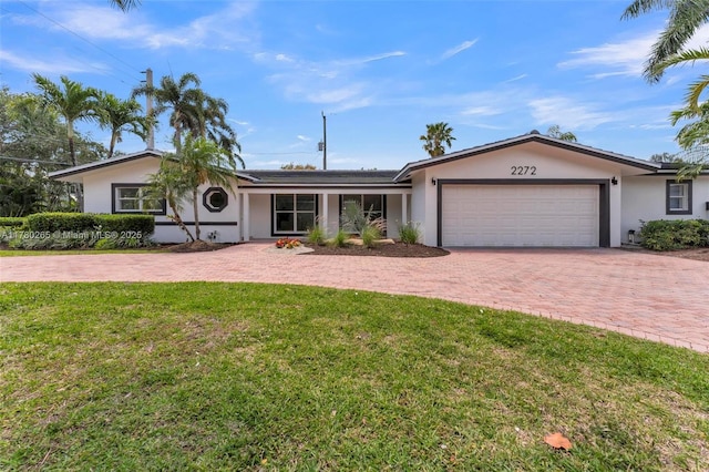 2272 NE 31st St, Lighthouse Point, FL 33064 - ranch-style house with stucco siding, an attached garage, decorative driveway, and a front yard