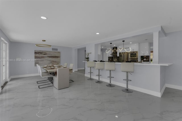 2272 NE 31st St, Lighthouse Point, FL 33064 - kitchen featuring white cabinets, a kitchen bar, modern cabinets, stainless steel refrigerator with ice dispenser, and recessed lighting