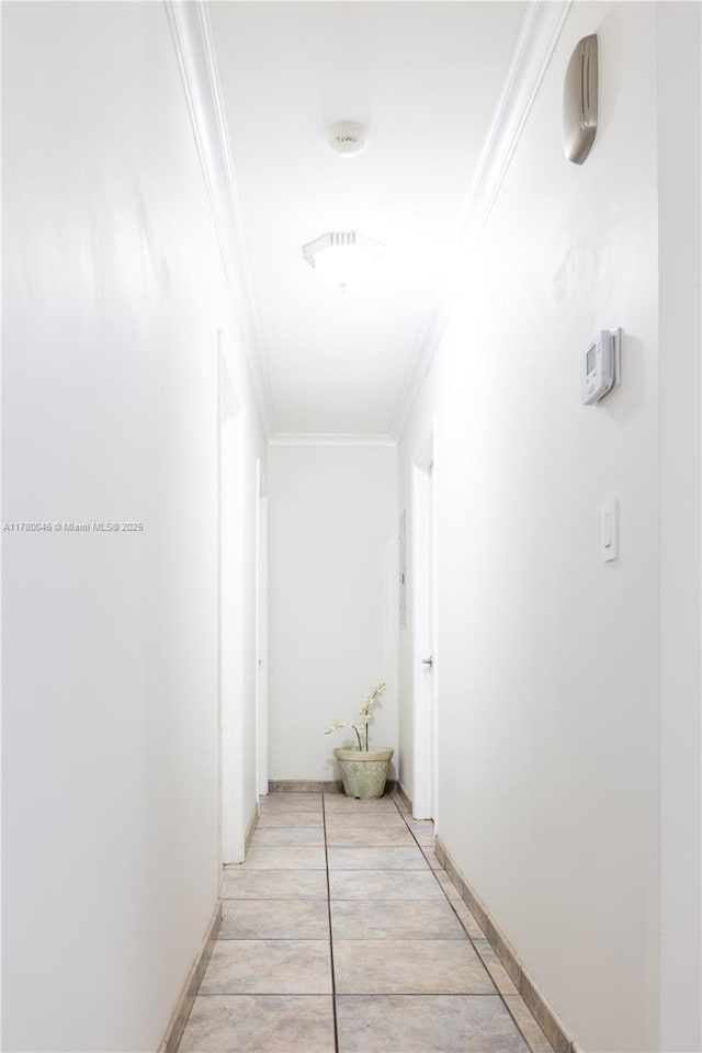 corridor with ornamental molding and baseboards