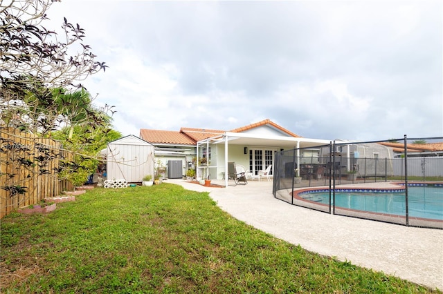 rear view of house with french doors, a tile roof, a patio area, and stucco siding
