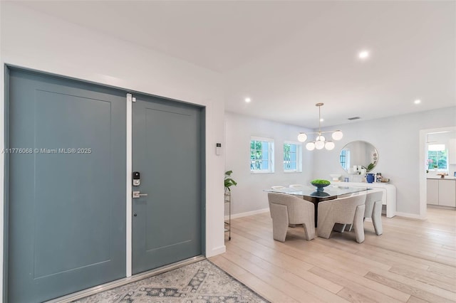 foyer entrance featuring baseboards, recessed lighting, an inviting chandelier, and light wood-style floors