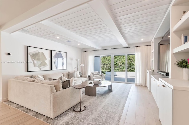 living area featuring beam ceiling and light wood-type flooring
