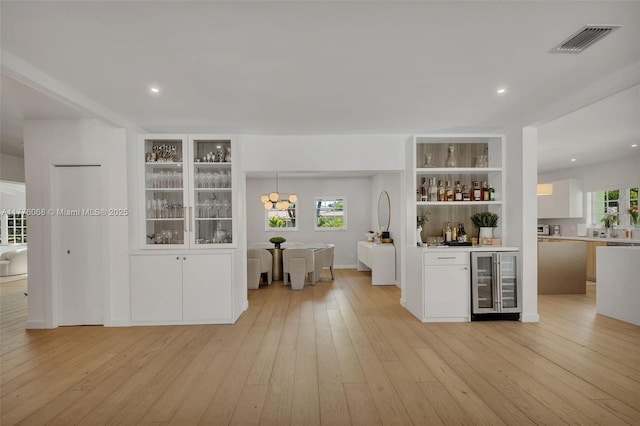 bar with bar, light wood-style flooring, visible vents, recessed lighting, and wine cooler