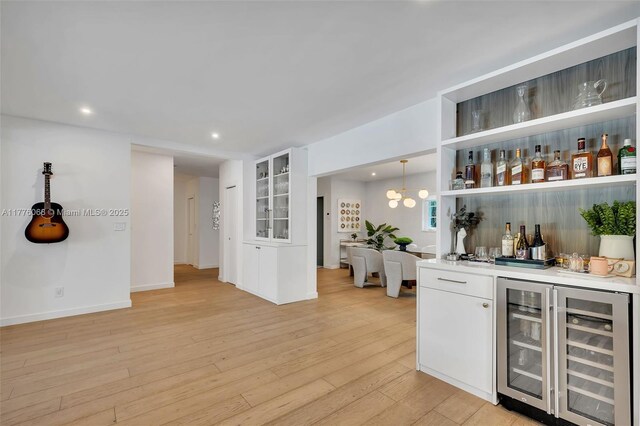 bar with baseboards, a dry bar, wine cooler, light wood finished floors, and recessed lighting
