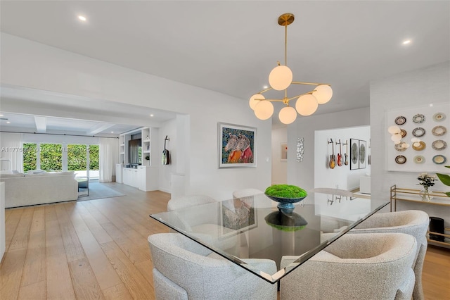 dining area with light wood finished floors, a notable chandelier, and recessed lighting
