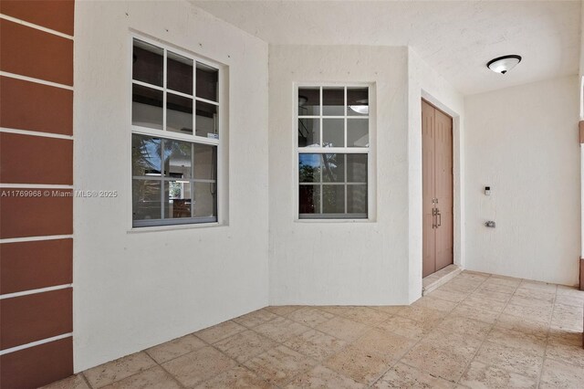 16477 SW 67th Ter, Miami, FL 33193 - view of exterior entry featuring stucco siding and a patio area