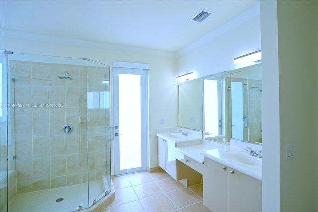 bathroom with a shower stall, vanity, tile patterned floors, crown molding, and visible vents