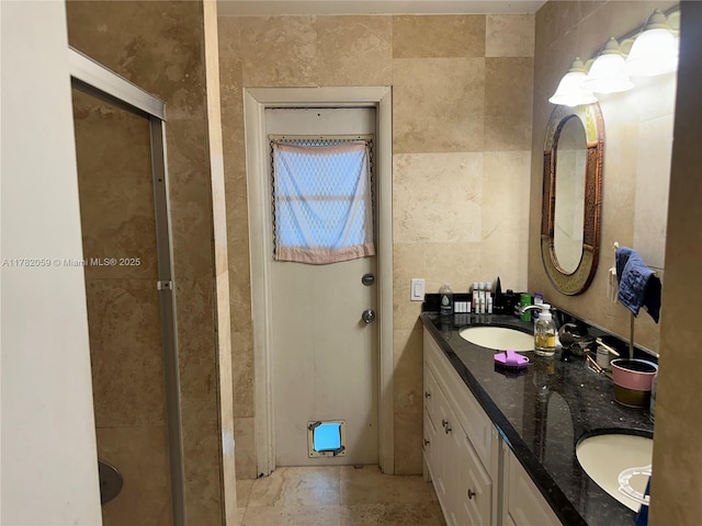 bathroom with double vanity, tile walls, and a sink