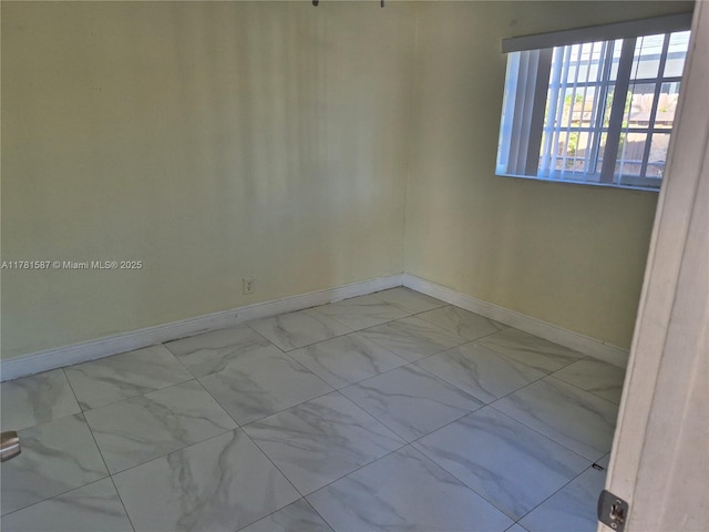 unfurnished room with baseboards and marble finish floor