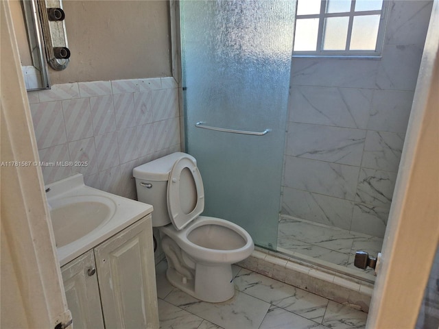 full bath with vanity, tile walls, a stall shower, toilet, and marble finish floor