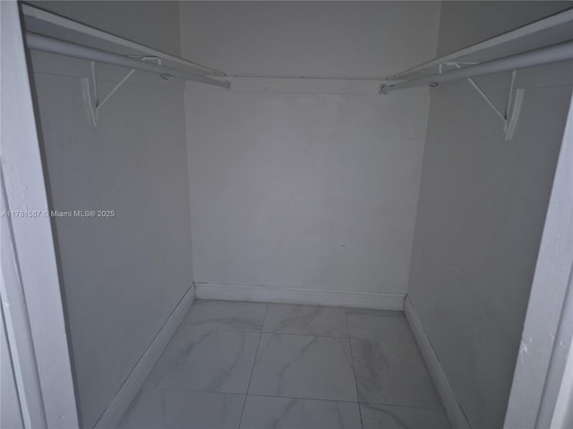 walk in closet with marble finish floor
