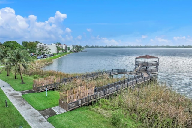 dock area featuring a yard, a water view, and fence