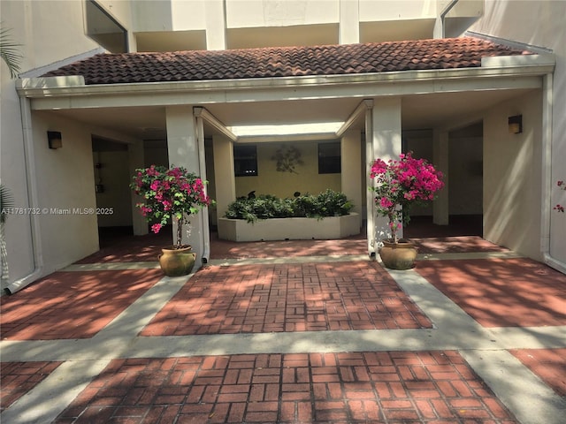 doorway to property with a tiled roof and stucco siding