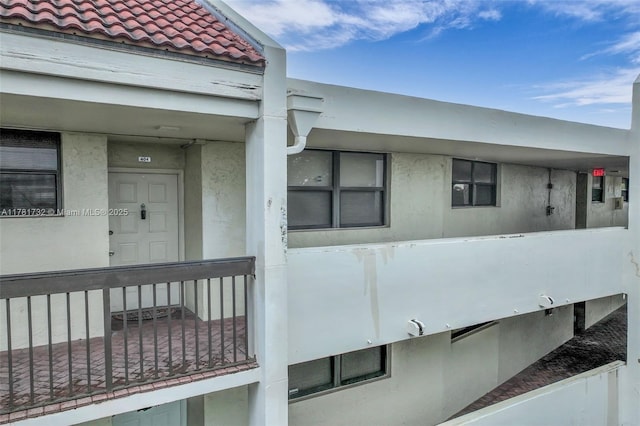 exterior space with a tiled roof and stucco siding