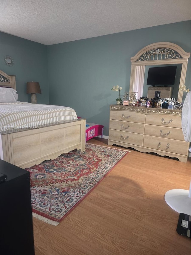 bedroom featuring wood finished floors and a textured ceiling