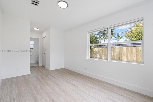 spare room with baseboards, visible vents, and light wood-style flooring