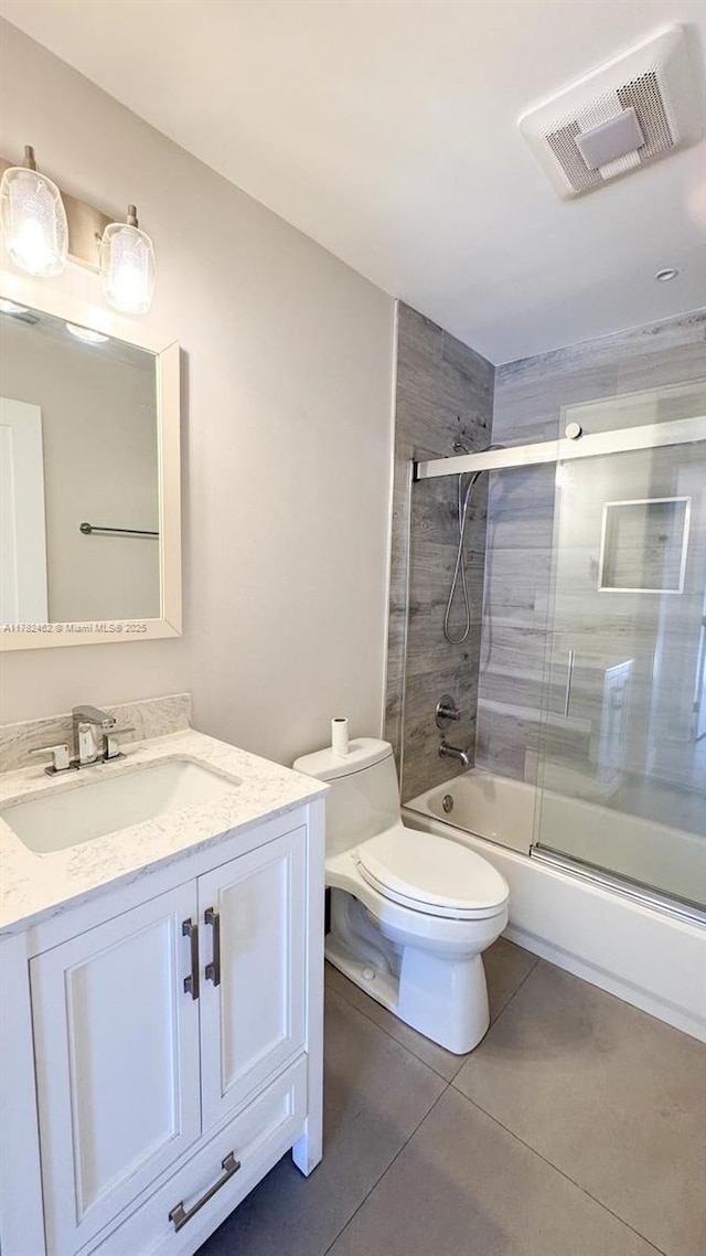 bathroom with combined bath / shower with glass door, vanity, tile patterned flooring, toilet, and visible vents