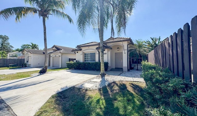 mediterranean / spanish-style house with stucco siding, fence, and a tile roof