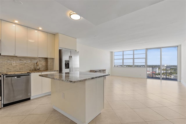 2100 Sans Souci Blvd Unit A1509, North Miami, FL 33181 - kitchen featuring open floor plan, light tile patterned floors, stone countertops, backsplash, and appliances with stainless steel finishes