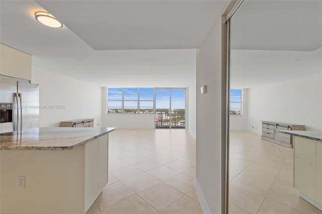 2100 Sans Souci Blvd Unit A1509, North Miami, FL 33181 - kitchen with stainless steel fridge, baseboards, open floor plan, and light tile patterned floors