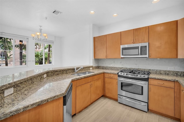 2925 NW 126th Ave Unit 223-1, Sunrise, FL 33323 - kitchen featuring appliances with stainless steel finishes, a chandelier, light stone counters, recessed lighting, and light wood-style flooring