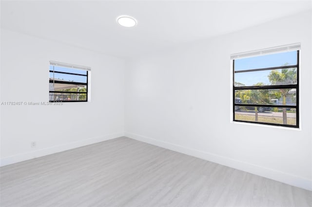 empty room featuring baseboards and wood finished floors