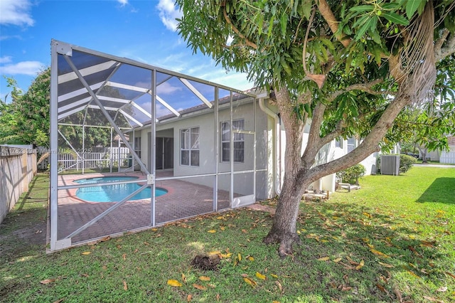 rear view of property with a patio, a fenced backyard, a fenced in pool, a lawn, and central air condition unit