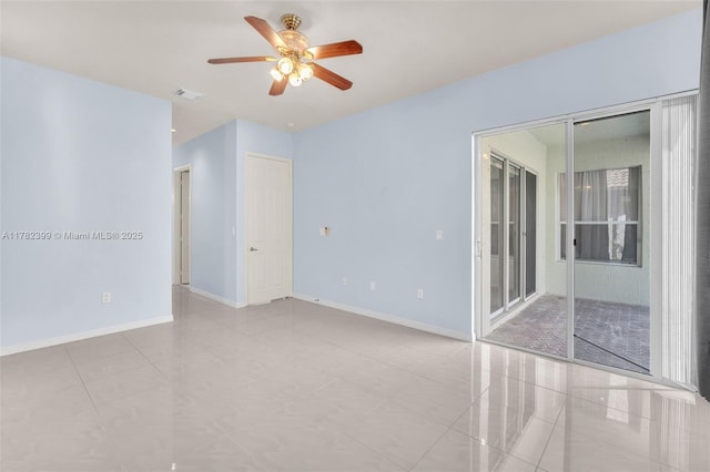 tiled empty room with visible vents, baseboards, and ceiling fan